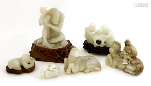 A collection of Chinese jade carvings, 20th century, comprising: a bearded man seated on the back ...