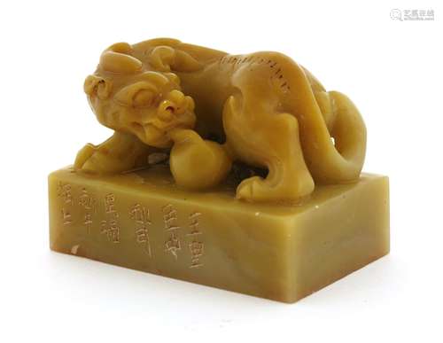 A Chinese soapstone seal, carved with a chilong, playing with a ball on a rectangular plinth, ...