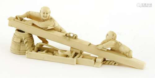 A Japanese ivory okimono, Meiji period (1868-1912), of a carpenter and his son planing a section of ...