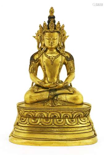 A Chinese gilt bronze bodhisattva, seated cross-legged on a double lotus pedestal, his hands ...