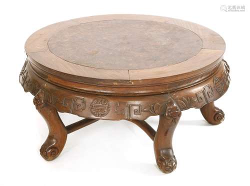 A Chinese low table, early 20th century, the circular top above shaped aprons carved with shou ...