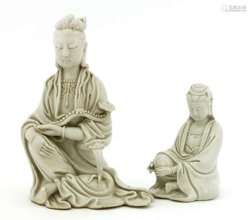 Two Chinese blanc de Chine Guanyin, one seated with his left arm resting on a mask and claw ...