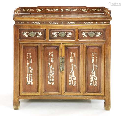 A Chinese side cabinet, early 20th century, with a shaped gallery on a rectangular top, above three ...