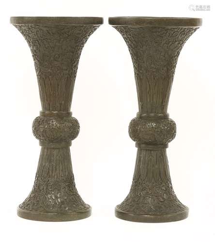 A pair of Chinese bronze vases, 18th century, of gu form, each with a flared top cast in relief ...