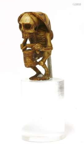 A Japanese ivory carving, Meiji period (1868-1912), of a stooped skeleton with a lamp in his left ...