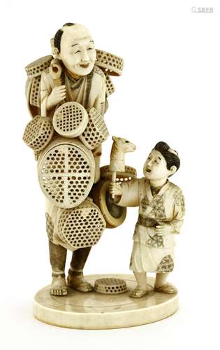 A Japanese ivory okimono, c.1920, of a basket seller, with a bamboo yoke hung on his shoulder with ...