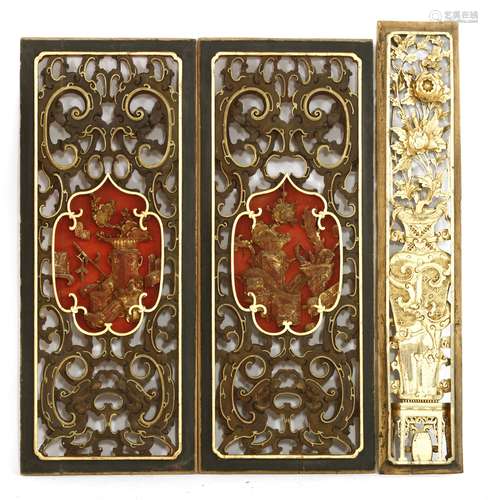 A pair of Chinese wooden door panels, early 20th century, each with vases of prunus and precious ...