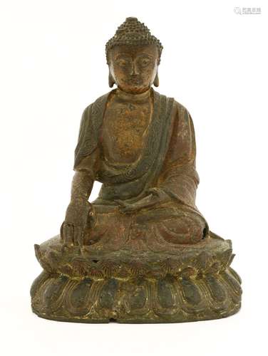 A Chinese bronze buddha, early Qing dynasty, wearing a long robe with scrolling borders, seated ...