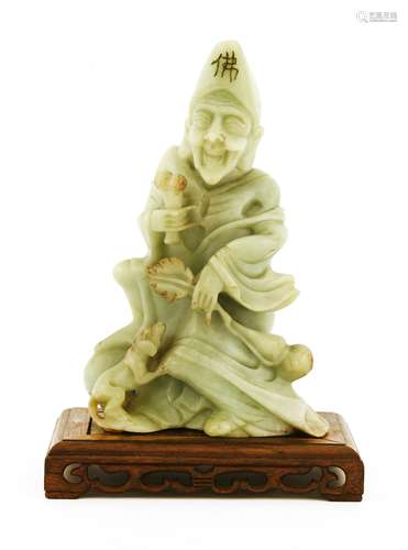 A Chinese soapstone carving, 20th century, of Ji Gong teasing a dog with a bone in his right hand, ...