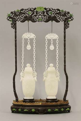 A pair of Chinese jade vases and covers, 19th/20th century, each of baluster form carved with a ...