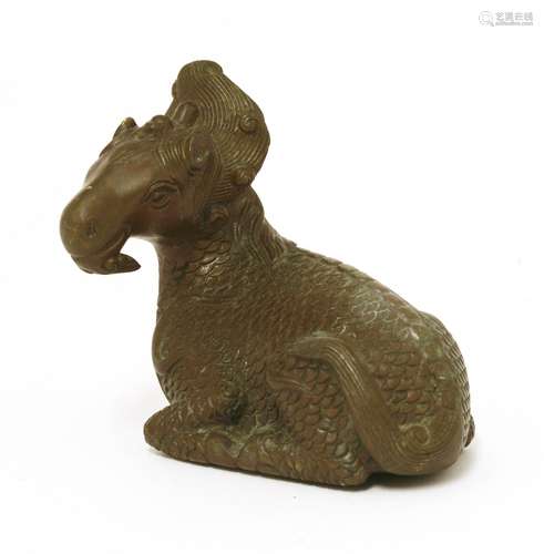 A Chinese bronze qilin, recumbent with its head turning to the left, details engraved, 6.5cm long