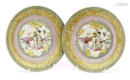 A pair of Chinese famille rose ruby back plates, each painted with a lady and boys in a sitting ...