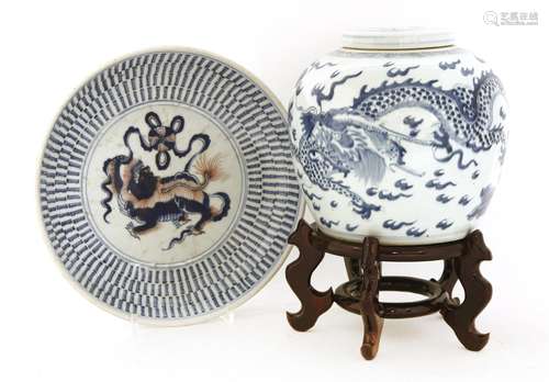 A Chinese blue and white plate, 19th century, painted with a Buddhist lion playing with a ball in ...