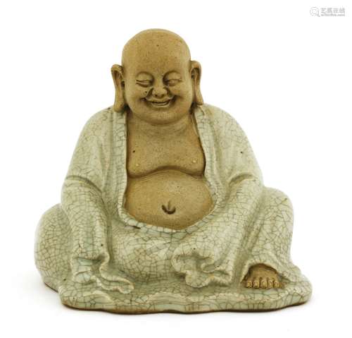 A Chinese figure, of Budai, seated wearing a long robe with a crackled glaze on a celadon ground, ...