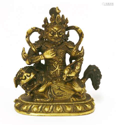 A Chinese gilt bronze bodhisattva, seated on the back of a Buddhist lion and dressed in full armour ...