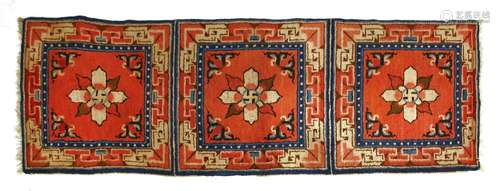 A Chinese Ningxia triple mat, decorated with florets within a key fret border against a red ground, ...