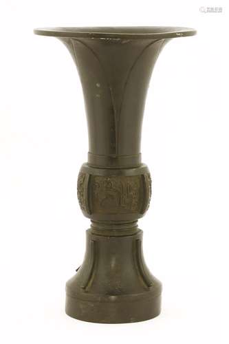 A Chinese bronze vase, 18th century, of gu form, the flared top with four upright petals, the body ...