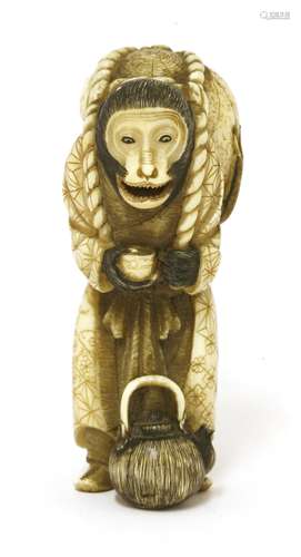 A Japanese walrus ivory okimono, Meiji period (1868-1912), of a monkey carrying a skull on his ...