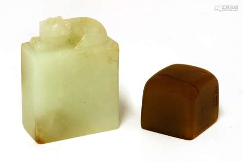 Two Chinese jade seals, one of rectangular form carved with a Buddhist lion, the stone in white ...