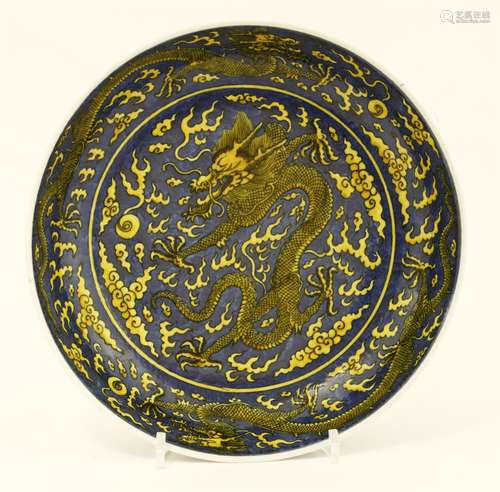 A Chinese porcelain plate, painted with dragons chasing flaming pearls amongst clouds in yellow ...