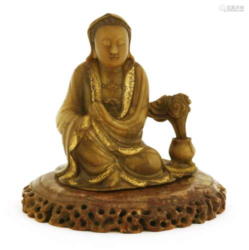 A Chinese soapstone figure, of Guanyin seated on a shaped platform imitating rocks, wearing a long ...