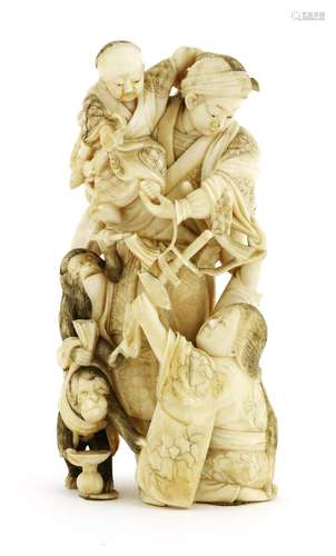 A Japanese ivory okimono, Meiji period (1868-1912), of a samurai holding a boy in his arms, a lady ...