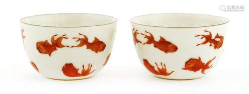 A pair of Chinese tea cups, 19th century or later, painted with goldfish in iron red, six character ...