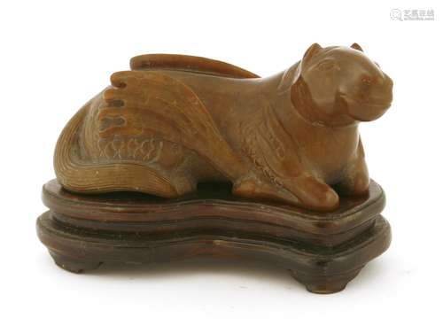 A Chinese hardstone carving, of a recumbent mythical horse with wings, the stone in a brown tone, ...