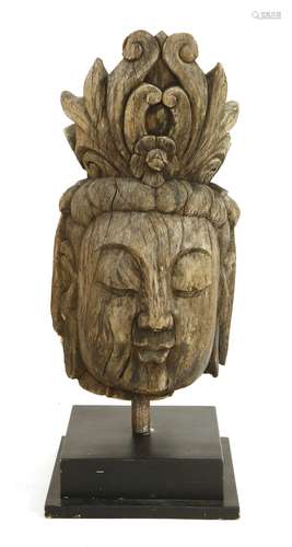 A large Chinese wooden carving, of a bodhisattva head, wearing an elaborate headdress, his eyes ...