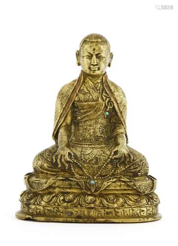 A Chinese Tibetan bronze figure,  16th century, of a guru, seated cross-legged on a lotus pedestal ...