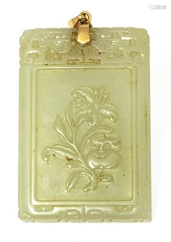 A Chinese jade pendant, 20th century, of rectangular form, carved with a lily and a persimmon fruit ...