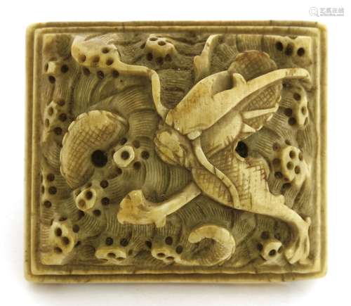 A Chinese ivory buckle, Ming dynasty, 17th century, carved with a dragon amongst spuming waves, ...