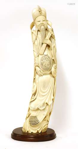 A Chinese ivory carving, late 19th century, of Cao Guojiu, standing in long robes with a dragon ...