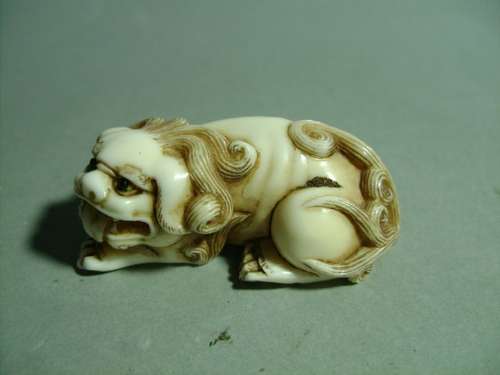 Netsuke en ivoire représentant un Shishi, parfait ...