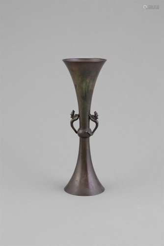 AN ARCHAISTIC BRONZE TRUMPET NECK VASE, with plain neck and lower section, centred with raised