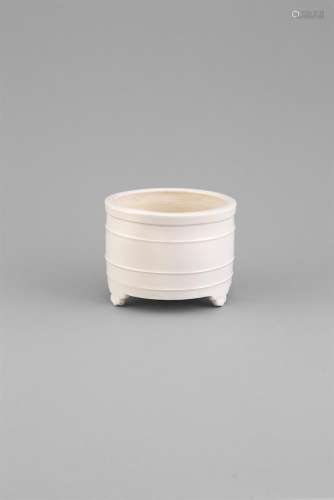 A BLANC-DE-CHINE RIBBED CENSER, 17th Century, of cylindrical form raised on three inverted 'ruyi'