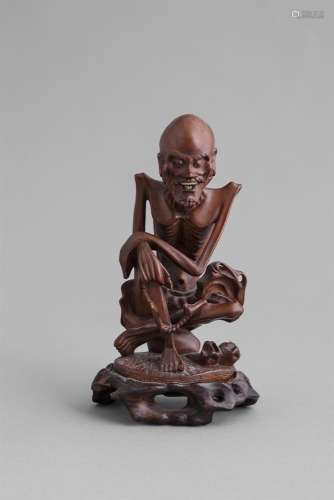 A CARVED BOXWOOD FIGURE OF A FASTING BUDDHA, 19th century, modelled in seated position with legs
