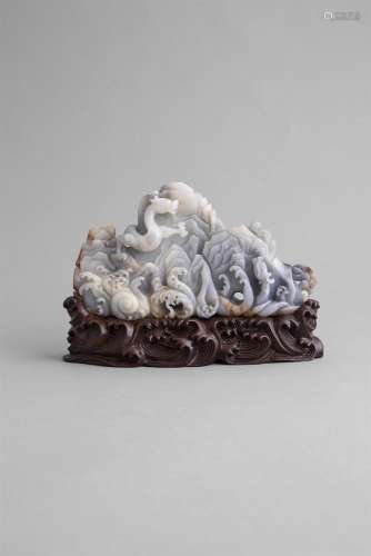 A WHITE, GREY AND RUSSET JADE 'DRAGON AND MOUNTAIN' BRUSH REST, formed as a dragon emerging from
