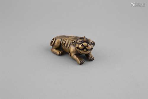 A BRONZE SCROLL WEIGHT, formed as a recumbent Luduan, c.1800, cast with outstretched fore paws, with