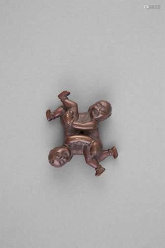 A BRONZE 'TWINS' SCROLL WEIGHT, 18th century, cast as a set of twins, depicted playfully and aligned