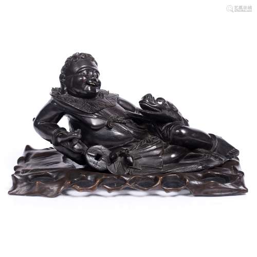 Hardwood recumbent figure Chinese, late 19th Century the figure's left hand resting on the head of a