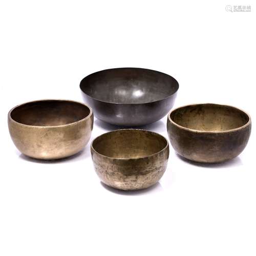 Four singing bowls Himalayan three of them decorated with circles around the edges the largest