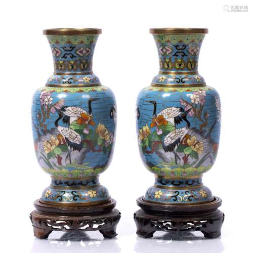 Pair of cloisonne vases Chinese, 20th Century depicting ducks and other birds, each on a hardwood