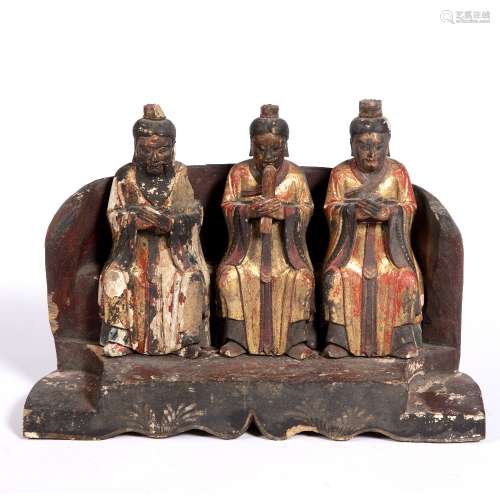 Three carved and lacquered scholars Chinese, 17th Century 25cm across