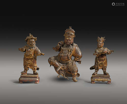 A RARE SET OF THREE CHINESE GILT AND LACQUERED BRONZE FIGURES OF GUANDI