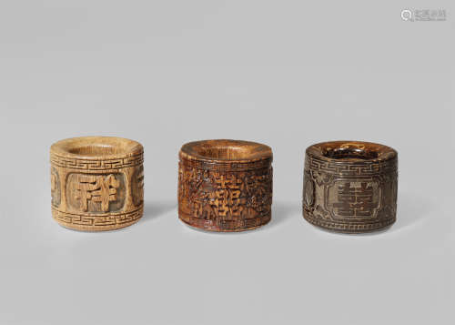 TWO CHINESE ALOESWOOD AND ONE CARVED COCONUT ARCHER'S RINGS