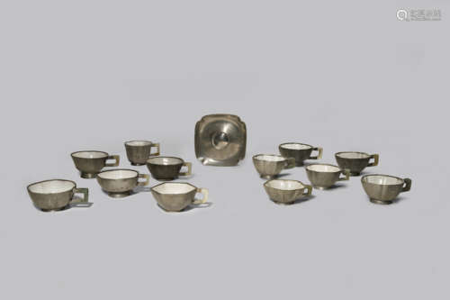 TWELVE CHINESE INSCRIBED PEWTER AND YIXING TEA CUPS AND A PEWTER CUP STAND