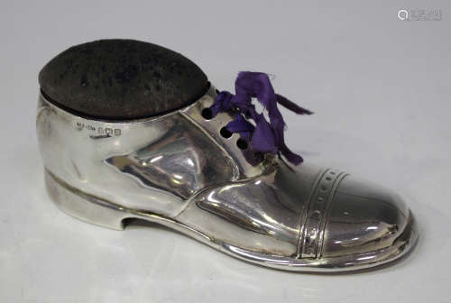 A George V silver mounted novelty pin cushion in the form of a laced shoe, the top fitted with a