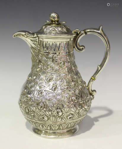 A Victorian silver water jug of baluster form with domed hinged lid and fruit finial above a scallop