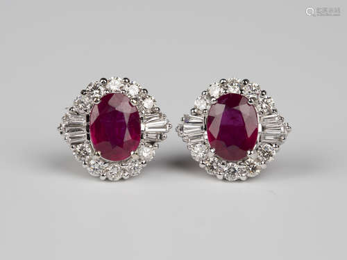 A pair of 18ct white gold, treated ruby and diamond cluster earrings, each claw set with an oval cut